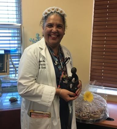 awardee wearing a headband of daisies, daisy award statue, and certificate.