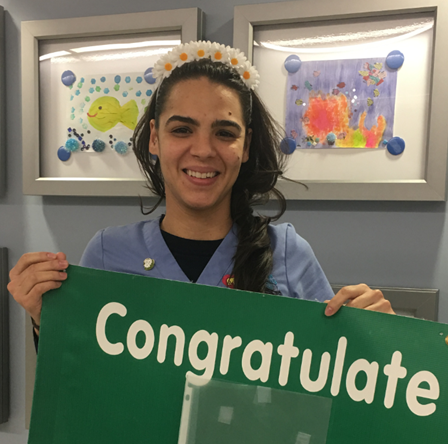 awardee wearing a headband of daisies, daisy award statue, and certificate.