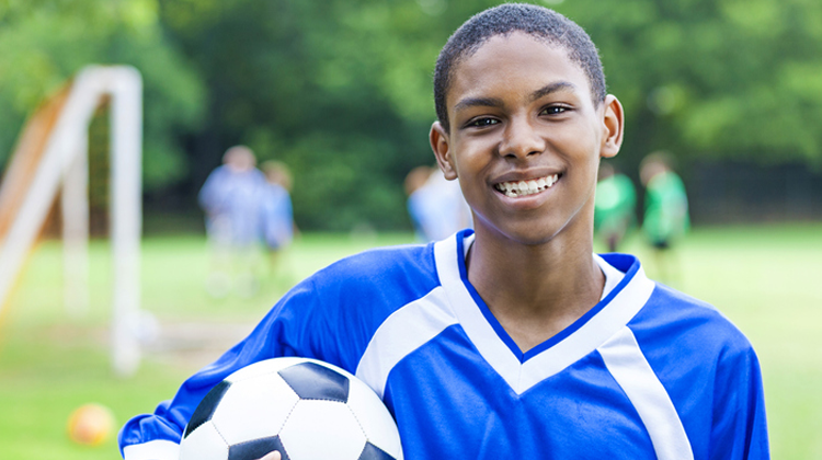 Boy soccer playing smiling at camera