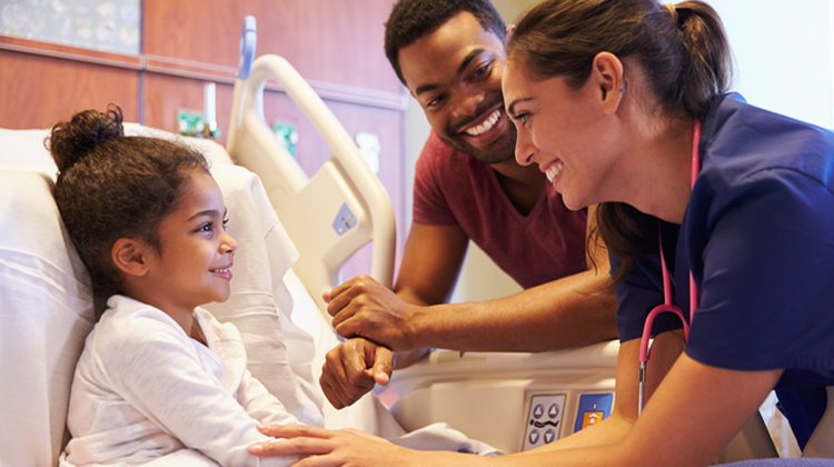 hospitalized girl and her dad smile at helpful nurse.