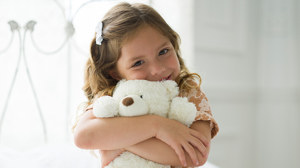 girl hugging teddy bear