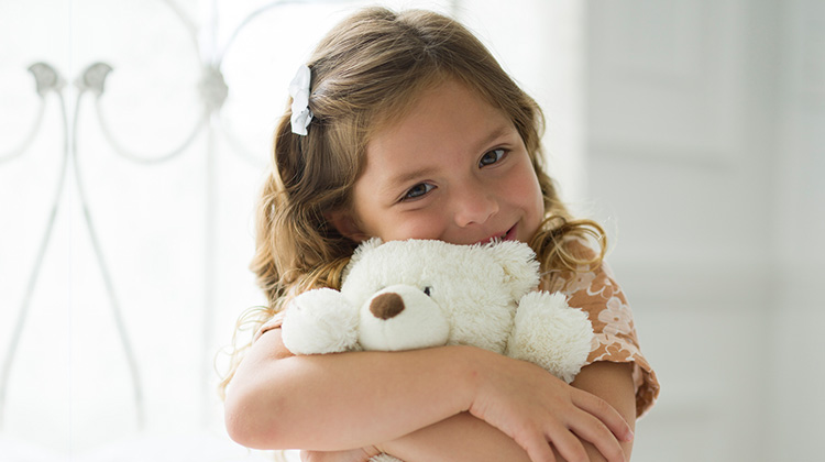 girl hugging teddy bear