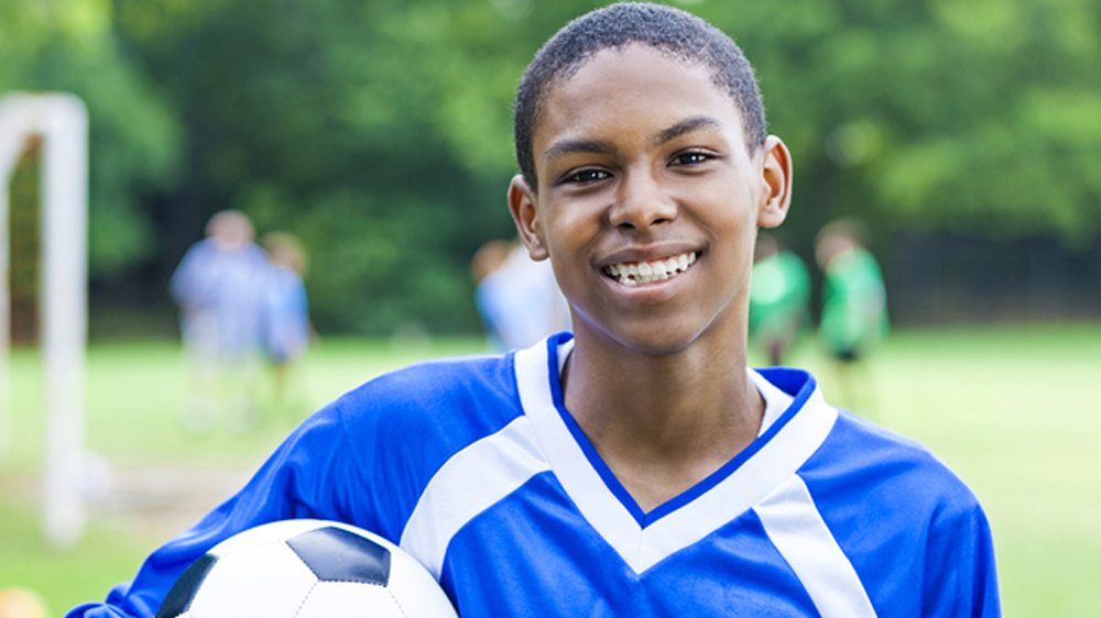 Boy soccer playing smiling at camera
