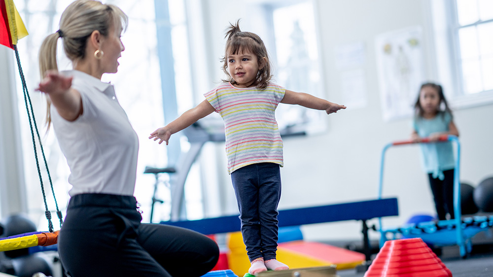 little girl during rehab exercises with therapist.