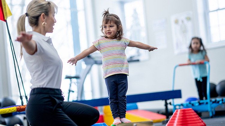little girl during rehab exercises with therapist.