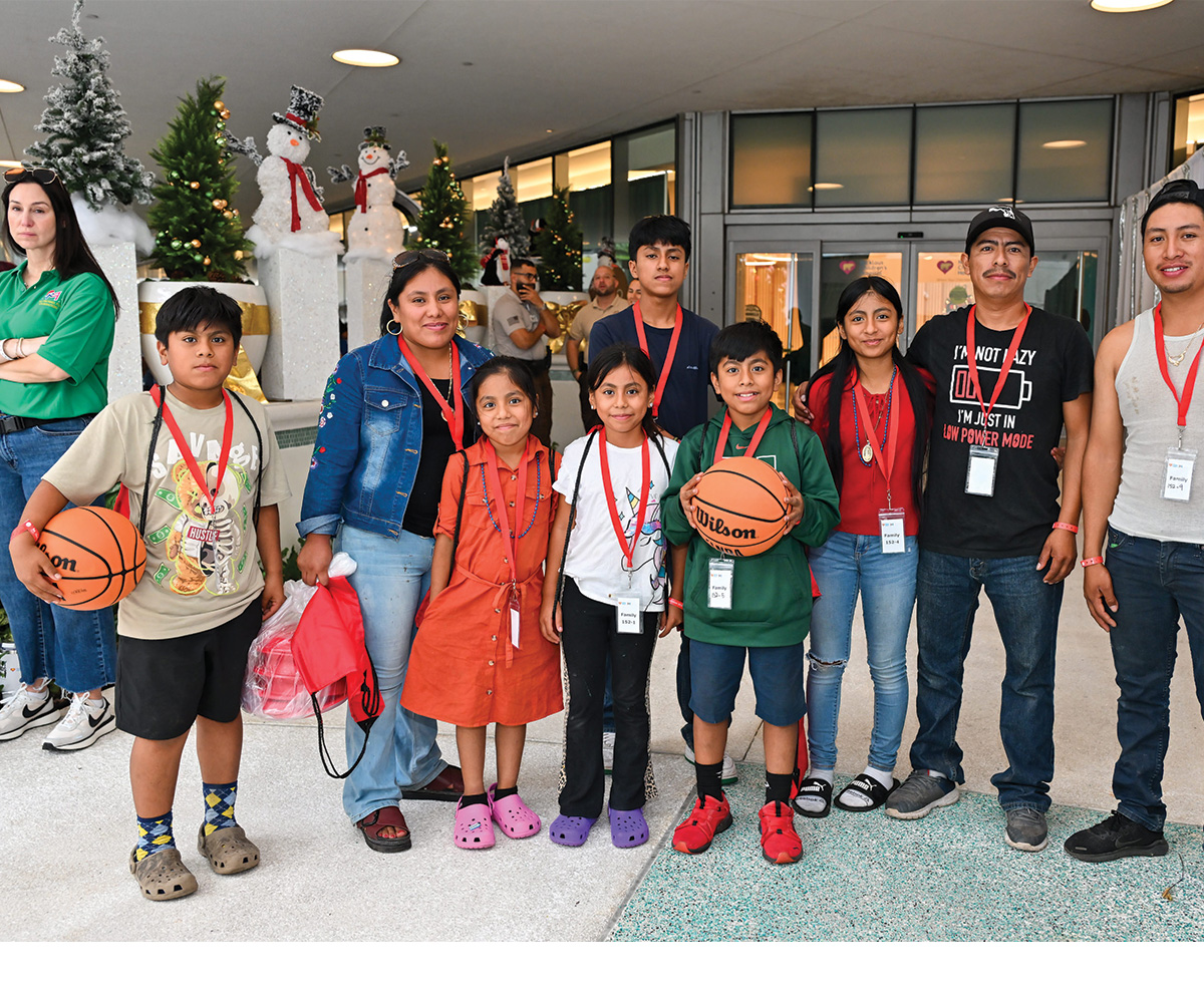 large family holding sporting gifts.