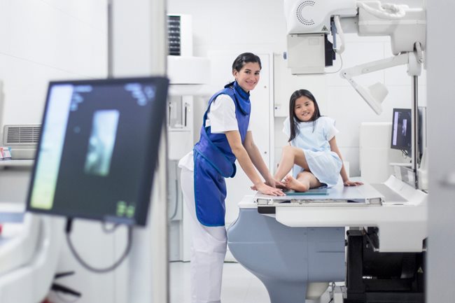 x-ray technician and girl sitting on the exam table.