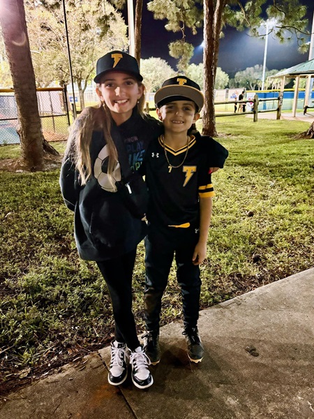 Rydon con su uniforme de béisbol y su hermana.